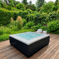 Infinitas the one whirlpool seitenansicht im garten mit wasser outdoor